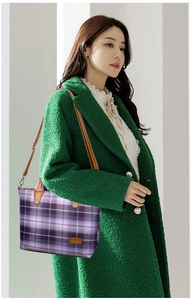 Detailed side view of purple plaid tote bag with brown leather handles worn by a model
