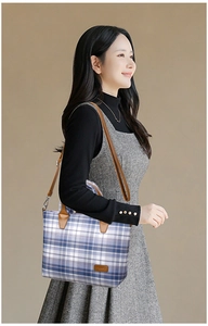 Detail of blue plaid tote bag with brown PU leather handles and adjustable shoulder strap