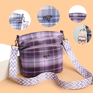 Detail of purple plaid crossbody bag with multiple zip pockets and patterned strap