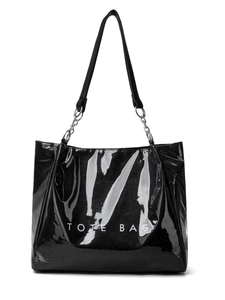 Détail du sac cabas noir brillant avec inscription blanche et bandoulière en chaîne
