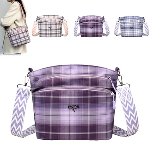 Close-up of plaid fabric bag with metal kangaroo logo and geometric wide strap