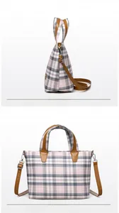 Detail of plaid canvas tote bag with pink and blue pattern and brown leather straps