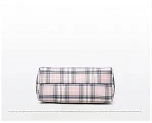 Detailed close-up of pink and grey plaid fabric texture and neat stitching on tote bag bottom