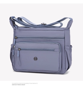Close-up of a multi-layer nylon crossbody bag in grey-blue with functional zippers