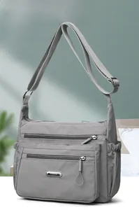 Detail view of water-resistant dark grey nylon bag with multiple zipper pockets