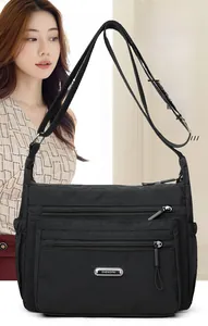 Medium black nylon crossbody bag featuring multiple zipper pockets and adjustable strap