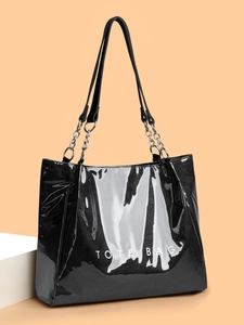 Vue détaillée du cabas noir brillant avec lettrage TOTE BAG et bandoulière en chaîne