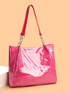 Gros plan d'un cabas magenta brillant avec chaîne en métal et texte TOTE BAG blanc
