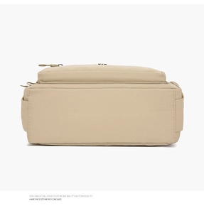 Detail view of khaki nylon shoulder bag showing back and side pocket construction