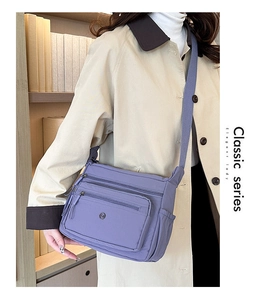 Close-up of purple lightweight nylon crossbody bag with three zipper compartments