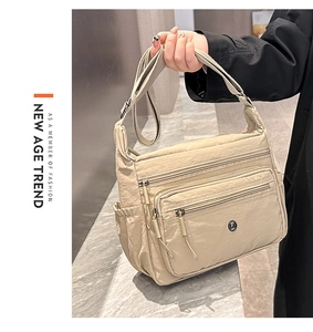 Detail view of lightweight nylon crossbody bag with multiple zip pockets and wide strap