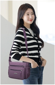 Detail of purple nylon crossbody bag with multi-zipper pockets and adjustable strap