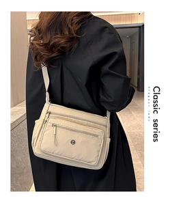 Detail of beige multi-pocket crossbody bag with adjustable wide shoulder strap