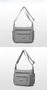 Close-up of grey nylon crossbody bag with multi-pocket design and adjustable strap
