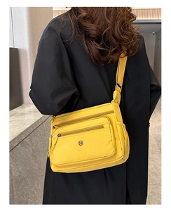 Detailed back view of a yellow nylon crossbody bag with multi-zippered pockets
