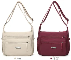 Close-up of nylon crossbody bag with dual zipper pockets and adjustable shoulder strap