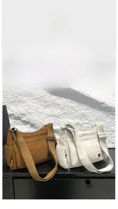 Detail of oxford cloth crossbody bags with multiple zippers and wide straps