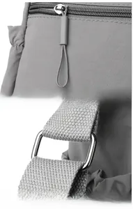 Detailed macro view of electroplated metal zipper pulls and strap buckles on grey nylon bag