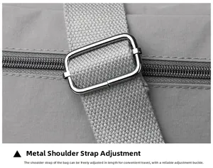 Detail of adjustable metal buckle and grey nylon woven strap on the shoulder bag