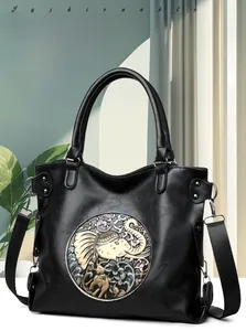 Detail of vintage style black leather tote with colorful circular elephant relief design