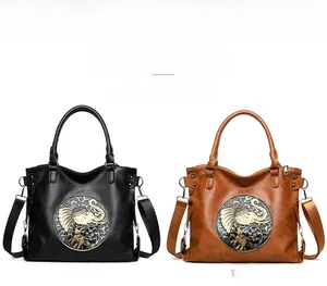 Detail view of vintage tote bags with ethnic elephant metal emblem in black and brown