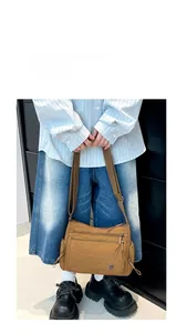 Brown nylon crossbody bag featuring three functional front zipper compartments and wide strap
