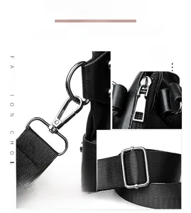 Detail of silver hardware and durable woven strap on black textured leather tote bag
