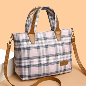 Pink plaid canvas tote bag with brown leather handles and adjustable shoulder strap