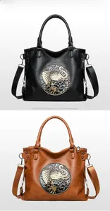 Close-up of black and brown tote bags with circular elephant embossing and woven straps