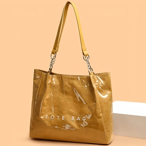 Sac fourre-tout jaune transparent avec bandoulière chaîne et texture papier sur fond orange