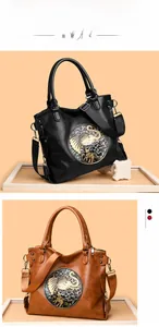 Close-up of vintage tote bag featuring a decorative elephant metal relief and adjustable strap