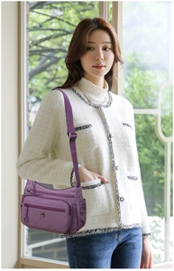 Détail du sac bandoulière en nylon violet avec plusieurs poches zippées et sangle réglable