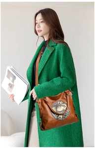 Detail of vintage brown tote bag with metallic elephant emblem and adjustable strap