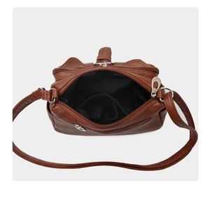 Detail view of large capacity dark brown crossbody bag with double zipper and inner pocket
