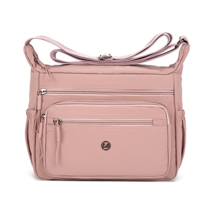 Lightweight pink nylon crossbody bag with three zipper pockets and adjustable strap