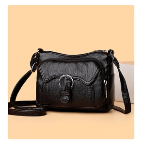 Detail of black washed leather crossbody bag with multiple zippers and silver ring buckle