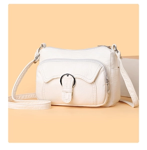 Close-up of white PU leather crossbody bag with multiple zippers and silver hardware
