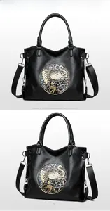 Front and side view of black tote bag with embossed elephant and floral pattern