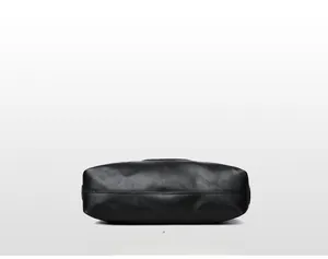 Detailed bottom view of black tote bag showing premium lychee grain texture and stitching