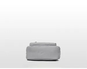 Vue détaillée du fond du sac bandoulière en nylon gris clair montrant coutures et texture
