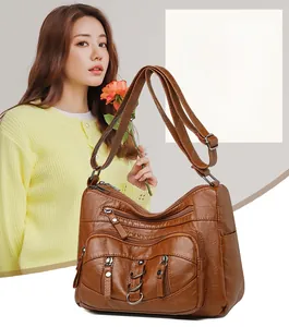 Detail of caramel brown multi-pocket crossbody bag with high-quality PU leather texture