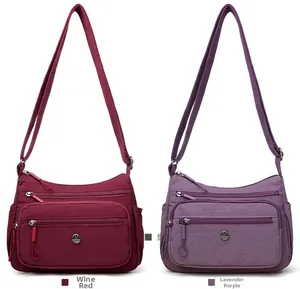 Détail de sacs bandoulière en nylon imperméable bordeaux et violet avec multi-poches