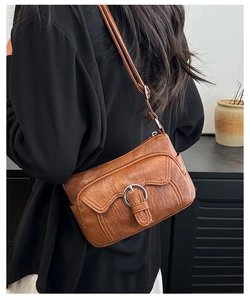 Brown vintage leather crossbody bag with multiple pockets and silver ring detail on model