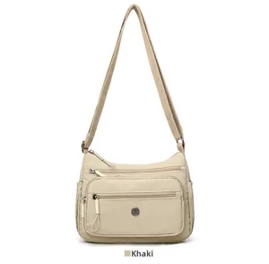 Détails du sac bandoulière en nylon kaki avec plusieurs poches zippées et sangle réglable