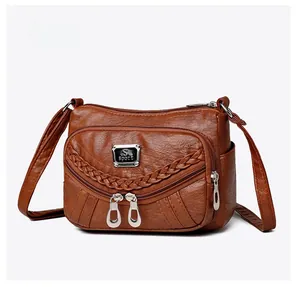 Detailed side view of dark brown soft leather crossbody bag with multiple zip pockets