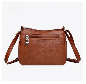 Detailed back view of brown PU leather crossbody bag featuring functional zipper pocket