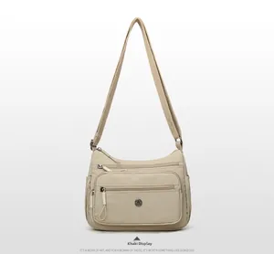 Vue détaillée du sac bandoulière en nylon kaki avec plusieurs zips et sangle réglable