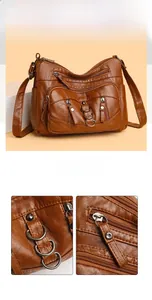 Detail of dark brown washed leather crossbody bag with zippers and bronze metal rings