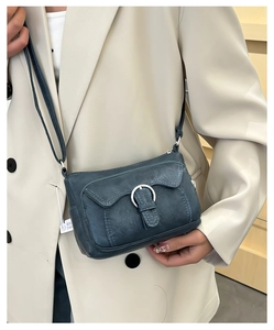 Detail of vintage grey faux leather shoulder bag with silver buckle and fold design