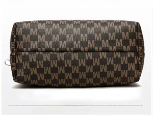Vue détaillée de la base robuste et du motif M rétro en cuir sur ce sac à bandoulière